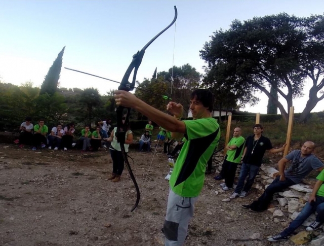 Tiro con arco frente a los colegas de trabajo